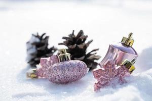 natal - enfeites decorados, bolas de natal rosa, pinho e flocos de neve em fundo nevando foto