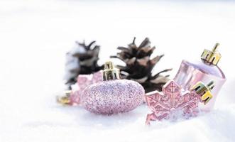 natal - enfeites decorados, bolas de natal rosa, pinho e flocos de neve em fundo nevando foto
