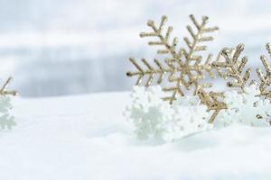 natal de inverno - bolas de natal com fita na neve, conceito de férias de inverno. bolas vermelhas de natal, bolas douradas, decorações de pinho e flocos de neve em fundo de neve foto