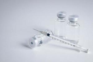 frasco de vacina antivírus com seringa colocada em um conceito de fundo branco de vacina para o coronavírus ou covid-19. serviços médicos hospitalares. espaço de cópia foto