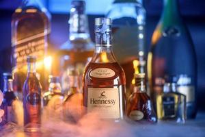 bangkok, tailândia - set. 07, 2022 garrafa hennessy, a famosa marca de conhaque de conhaque. frança e outras marcas de licor em segundo plano com gelo de fumaça legal foto
