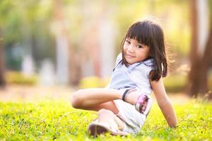 menina asiática na grama no jardim foto
