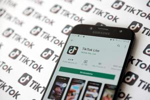 ternopil, ucrânia - 2 de maio de 2022 aplicativo para smartphone tik tok na tela e muitos logotipos tiktok impressos em papel. tiktok ou douyin é um famoso serviço chinês de hospedagem de vídeos curtos de propriedade da bytedance foto