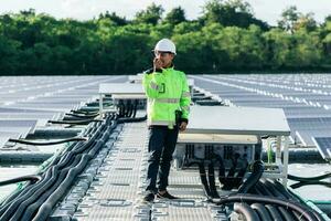 Planta de energia solar. homem de pé perto de painéis solares. energia renovável. foto