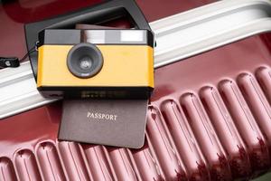 câmera vintage conceito de viagem em fundo cinza de bagagem vermelha, com espaço de cópia. mala e conceito de viagem de câmera de filme retrô. foto