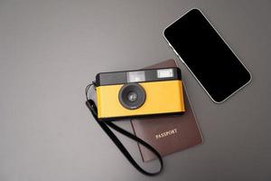 câmera vintage conceito de viagem, smartphone, passaporte, em fundo cinza, com espaço de cópia. foto