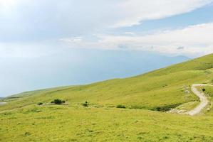 encosta verde das montanhas de monte baldo sobre garda lak foto