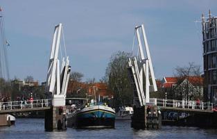 haarlem, holanda, 2019 - pessoas esperam em uma ponte em haarlem enquanto um navio passa por ela. foto