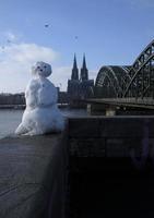 um boneco de neve em colônia, alemanha, com a famosa catedral ao fundo foto