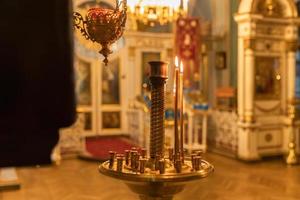 Igreja Ortodoxa. cristandade. decoração de interiores festiva com velas acesas e ícone na tradicional igreja ortodoxa na véspera de páscoa ou natal. religião fé rezar símbolo. foto