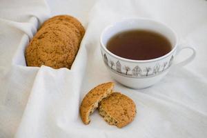 biscoitos de aveia caseiros com passas. biscoitos saudáveis. xícara de chá da manhã com biscoitos de aveia. foto