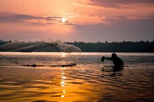 pescador lançando uma rede de pesca
