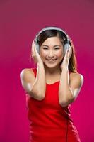 mulher asiática feliz ouvindo música em fones de ouvido.