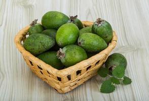 feijoa em uma cesta em fundo de madeira foto