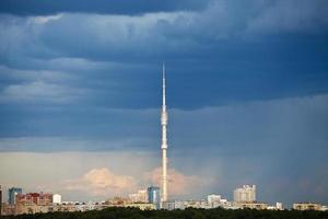 nuvens de chuva azul escura sobre torre de tv no verão foto