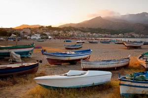 barcos na praia ao pôr do sol foto