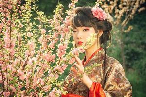 linda mulher asiática em flor de sakura foto