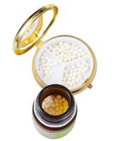 frasco de vidro e caixa de comprimidos com bolas de homeopatia foto