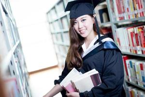 aluna linda asiática segurando o livro no retrato da biblioteca