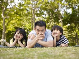 asiático pai e filhos se divertindo ao ar livre foto