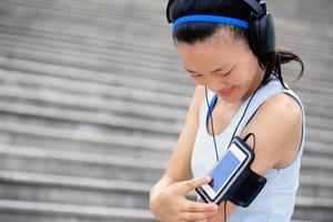 mulher ouvindo música em fones de ouvido do telefone inteligente mp3 foto
