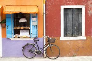 bicicleta perto de casa colorida na rua ilha de burano foto