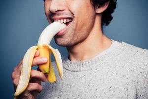 sorrindo jovem comendo uma banana