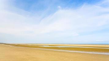 vista panorâmica do céu azul sobre a praia de areia amarela foto