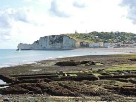 vila de etretat e penhasco na praia do canal inglês foto