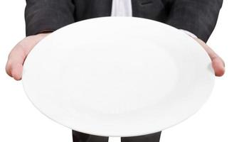 vista acima do empresário detém prato branco vazio foto
