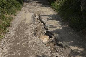 estrada ruim, buraco na estrada de asfalto nas terras altas após a estação chuvosa. foto