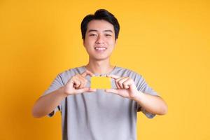 jovem asiático posando em um fundo amarelo foto