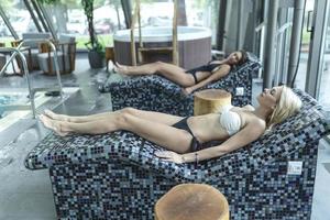 mulheres jovens relaxantes na sauna a vapor. mulheres com corpo esbelto e pele saudável descansando e fazendo procedimentos de spa no hammam ou banho turco