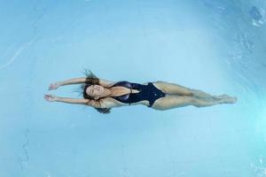 foto aérea de vista superior do drone voador de um modelo sexy sedutor em trajes de banho brancos está desfrutando de relaxar na piscina do hotel durante o fim de semana de verão. moda incrível mulher de biquíni tendo descanso de spa de luxo