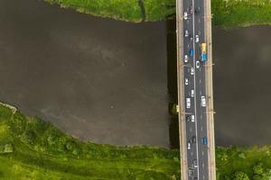 vista aérea no tráfego pesado em uma ponte com uma ampla estrada de várias pistas através de um rio largo foto