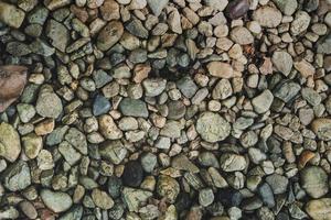 vista superior lisas redondas pedras de seixo abstrato textura de fundo. recreação de férias de férias no conceito de praia. conceito de textura de seixo de pedra da natureza. foto