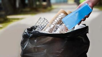 o dono da casa está separando garrafas, papel, caixas de ovos e outros materiais no saco plástico preto na frente da casa, conceito para reduzir o aquecimento global, salvar nosso mundo, foco suave e seletivo. foto