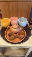 conjunto de equipamentos de serviço de chá poci ou poci. composto por bandeja, pote e copos com tampa, feitos à mão em barro ou cerâmica. foto