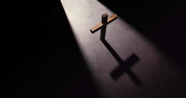 cruz cristã de madeira. conceitos de esperança, fé e religião. sombra clara da porta de abertura. vista do topo foto