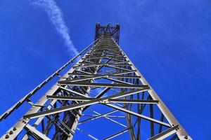 antena elétrica e torre transmissora de comunicação em uma paisagem do norte da Europa contra um céu azul foto