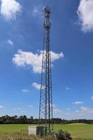 antena elétrica e torre transmissora de comunicação em uma paisagem do norte da Europa contra um céu azul foto