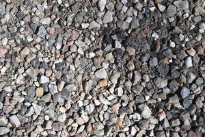 vista detalhada de perto em seixos e pedras em uma textura de terra de cascalho foto