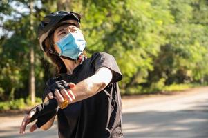 mulher ciclista sentindo calor dos raios uv enquanto anda de bicicleta na temporada de verão. radiação uv pode levar a sérios problemas de saúde, incluindo câncer. foto