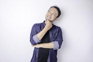 retrato de um jovem asiático pensativo vestindo camisa azul marinho olhando de lado imaginando escolhas foto