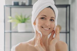 mulher hispânica, limpando a pele facial com almofadas de algodão após o banho, removendo a maquiagem. rotina de cuidados com a pele foto