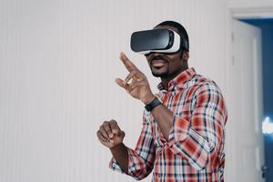 homem afro-americano em óculos de realidade virtual testando compra, compras no ciberespaço. comércio eletrônico foto