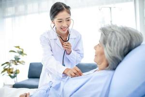 bela médica asiática com estetoscópio e pasta de documentos, examine o sintoma do paciente na sala de recuperação. conceito de saúde e medicina. foto