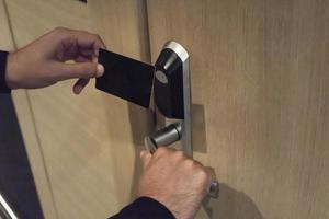 close-up do homem usando a chave do cartão e desbloqueando o quarto de hotel. foto