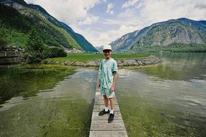 menino fica na pequena ponte de madeira em hallstatt, áustria. foto