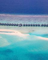 incrível atol e ilha nas maldivas da vista aérea. paisagem tropical tranquila e marinha com palmeiras na praia de areia branca, natureza pacífica na ilha resort de luxo. clima de férias de verão